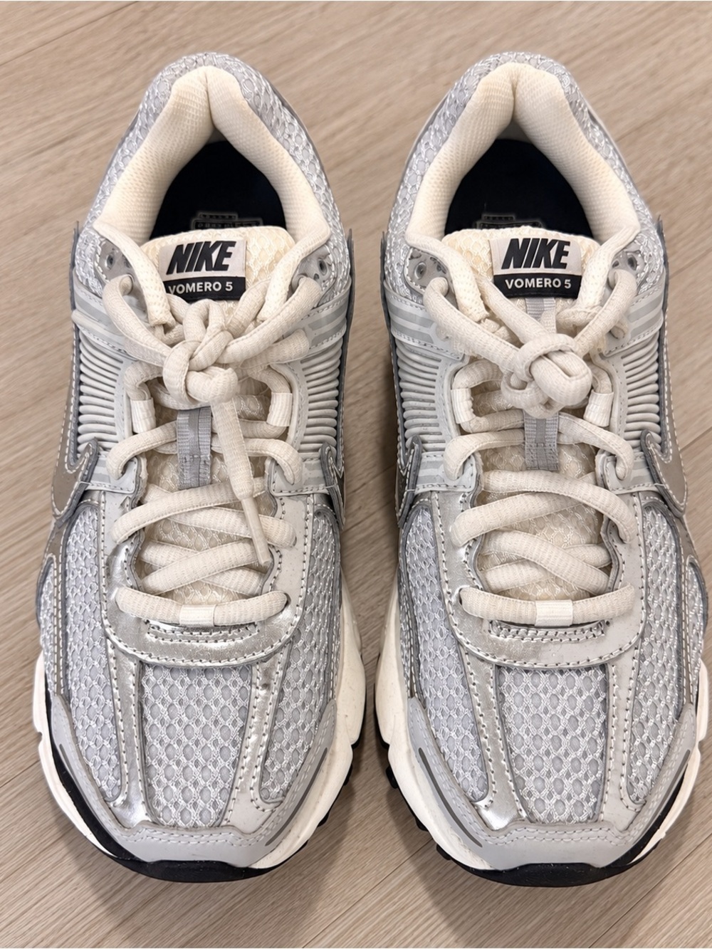 Nike Vomero 5 sneakers in metallic silver and white.